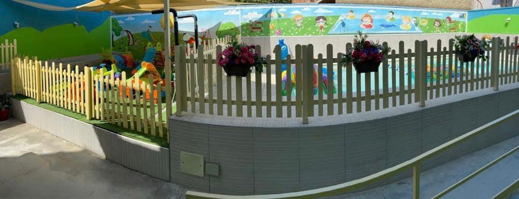 Area piscina con staccionata in legno e decorazioni